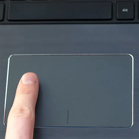 a finger is pressing a button on a laptop.