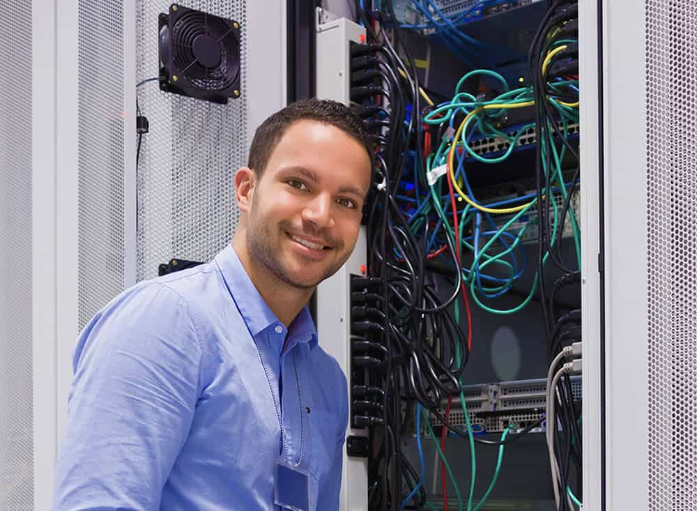 a man standing in front of a rack of wires.