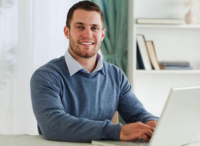 a man sitting in front of a laptop computer.