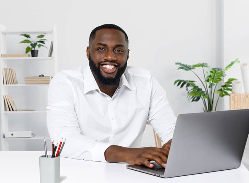 man smiling at his laptop