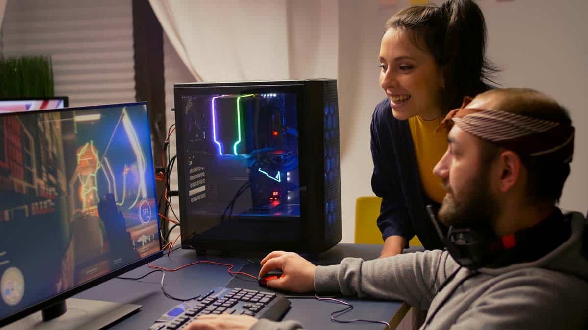 Young couple playing first person shooter game on a custom built Gaming Desktop Rig in Boulder Colorado
