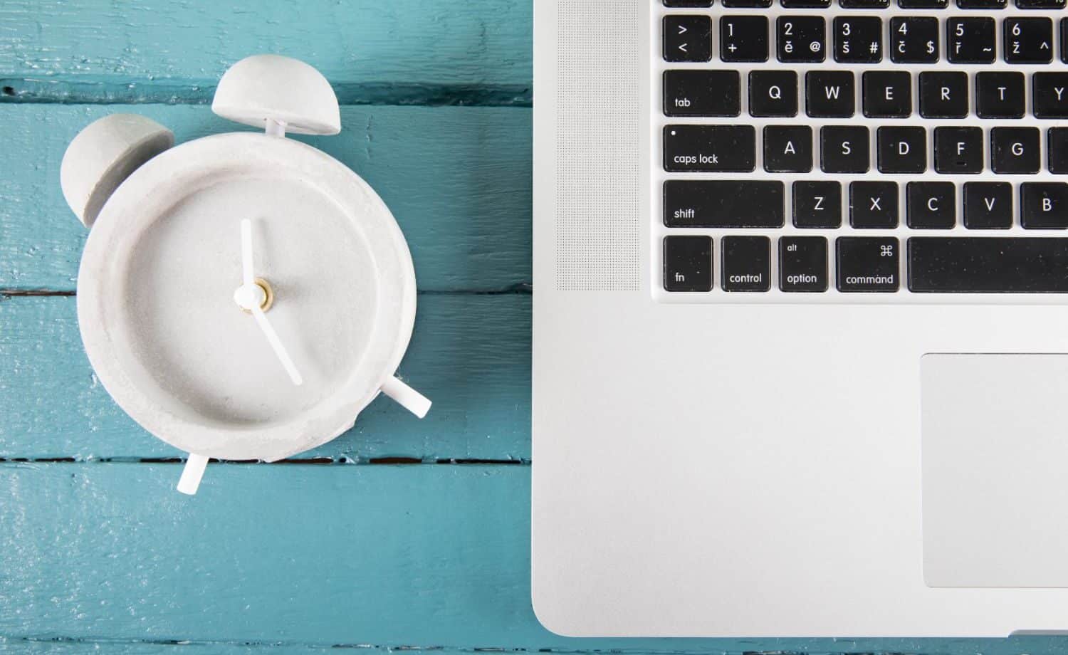 Laptop beside a clock
