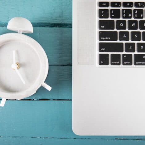 Laptop beside a clock