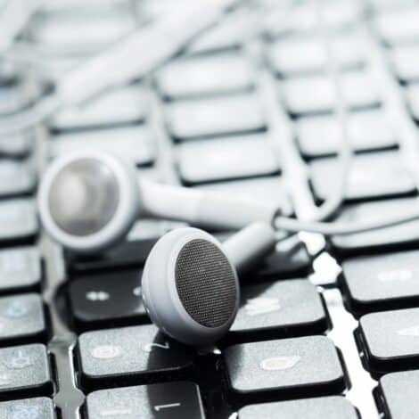 laptop keyboard with earbuds on top