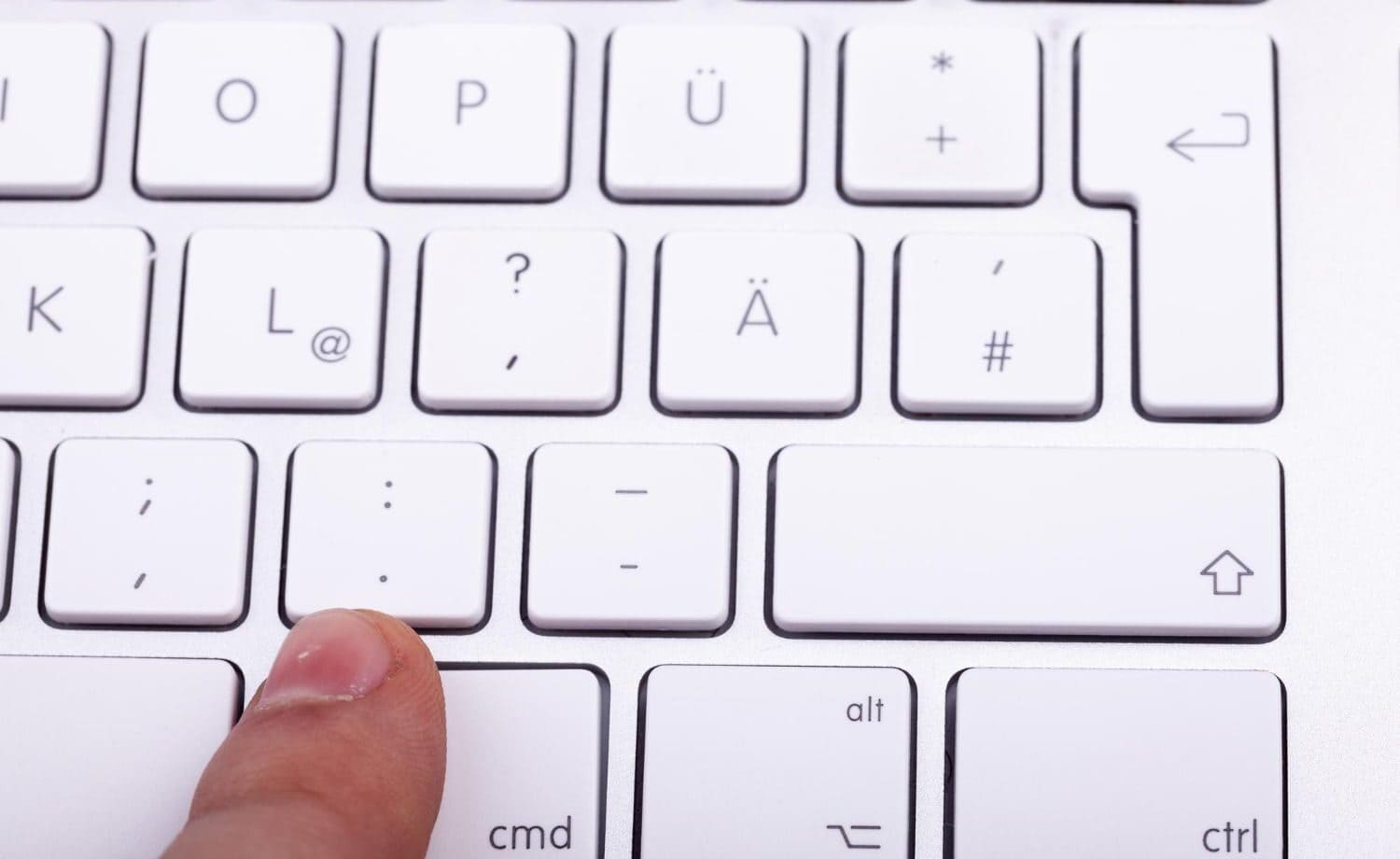 finger hovering over a keyboard