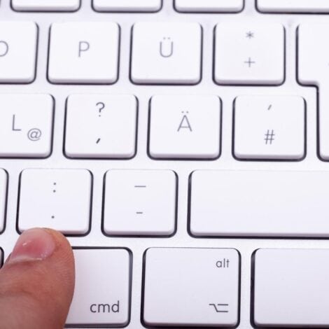 finger hovering over a keyboard