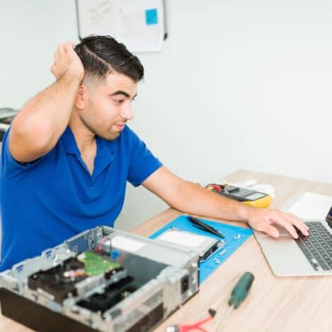Man frustrated with blue screen error on laptop