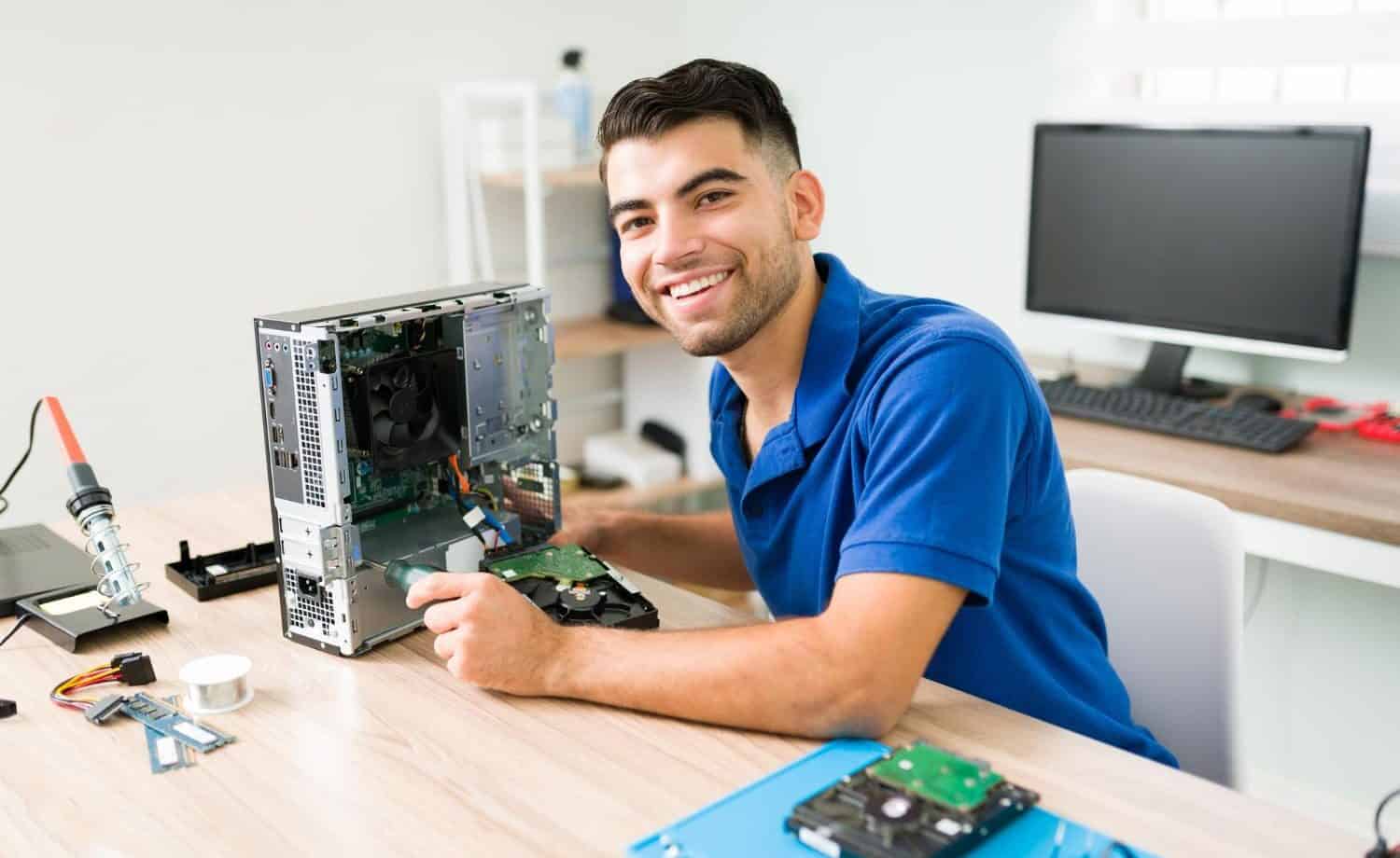 smiling man fixing a pc