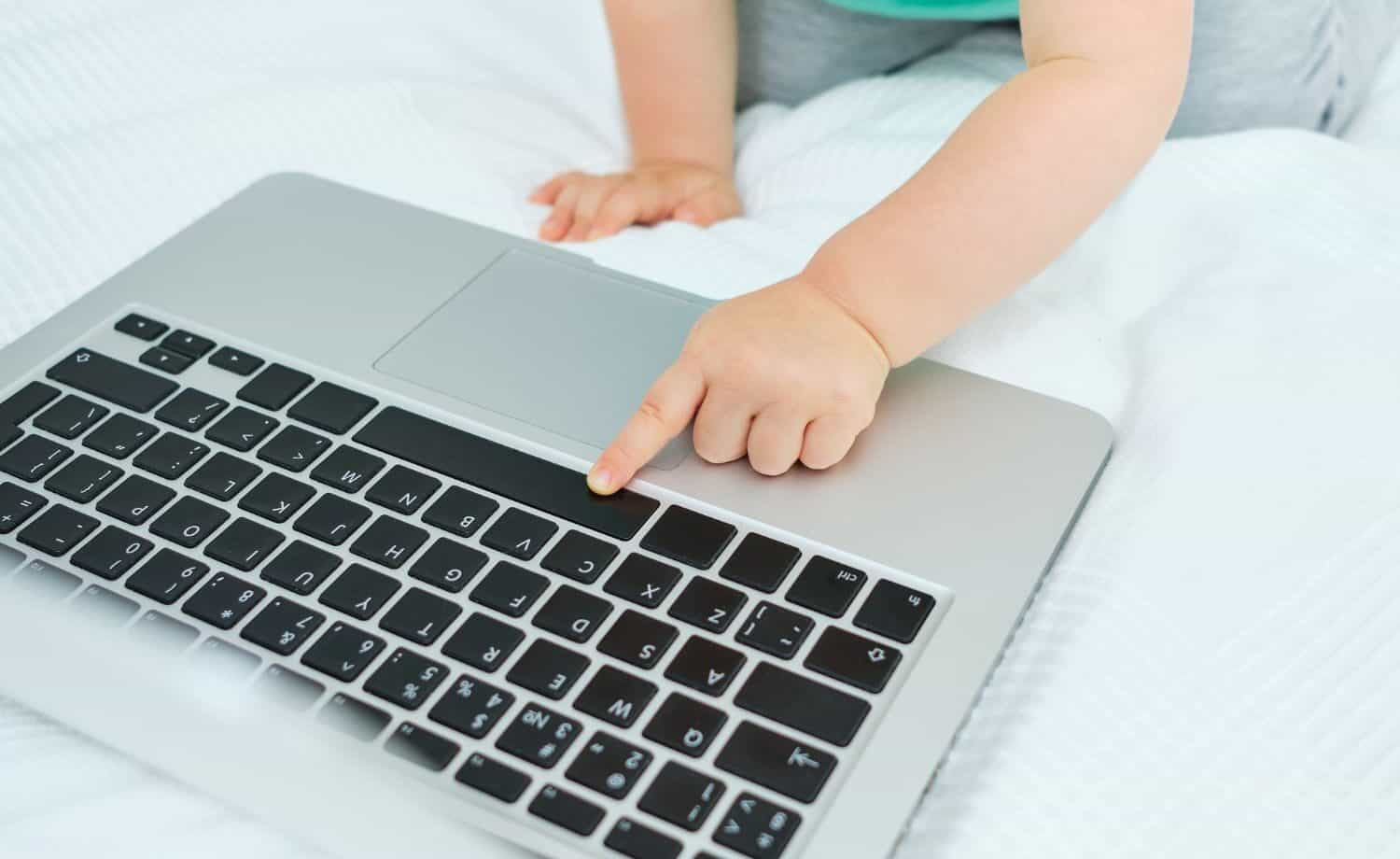 toddler crawling up t laptop