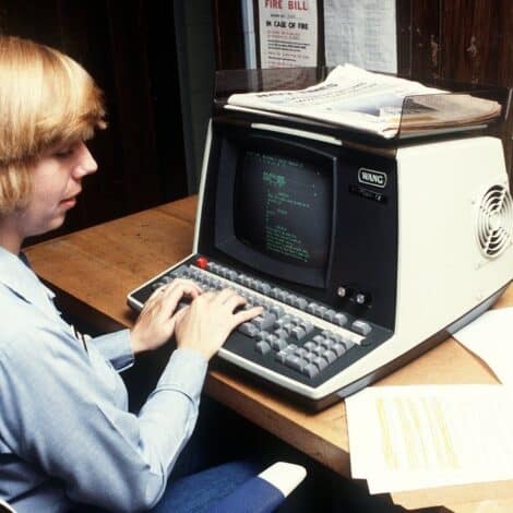 A woman typing on a vintage computer