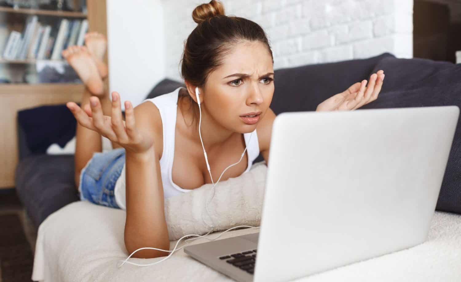 Frustrated woman at her laptop looking like "what the heck?!"