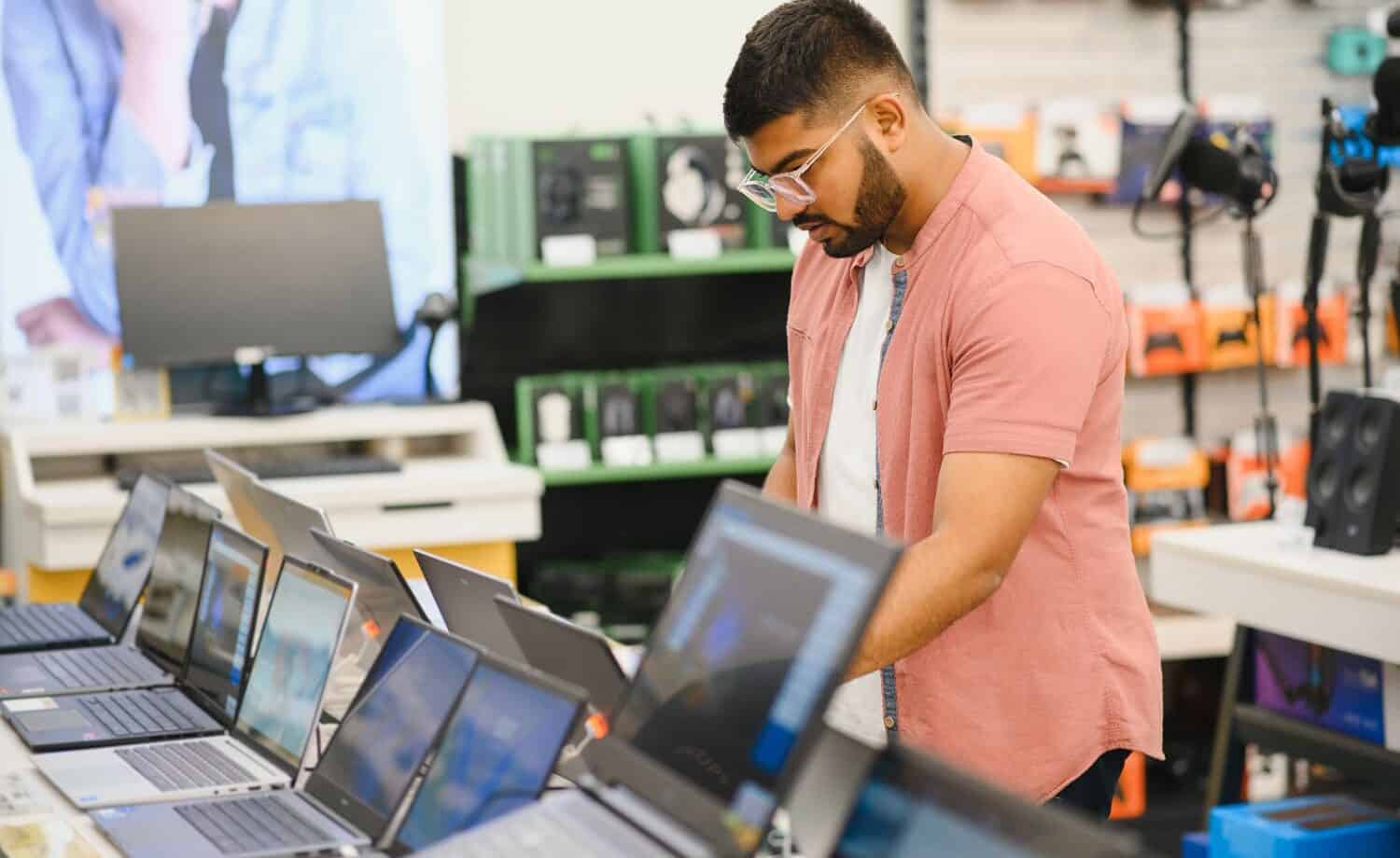 a man at a computer store shopping for a new computer