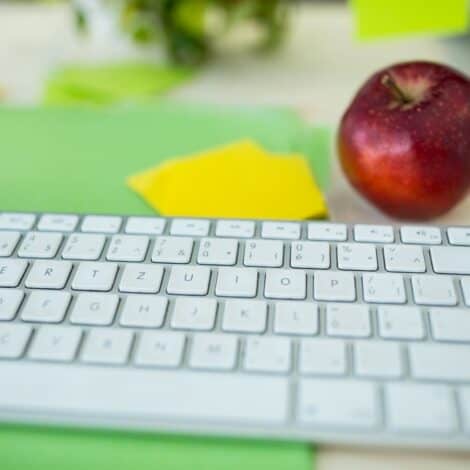 a computer keyboard and an apple