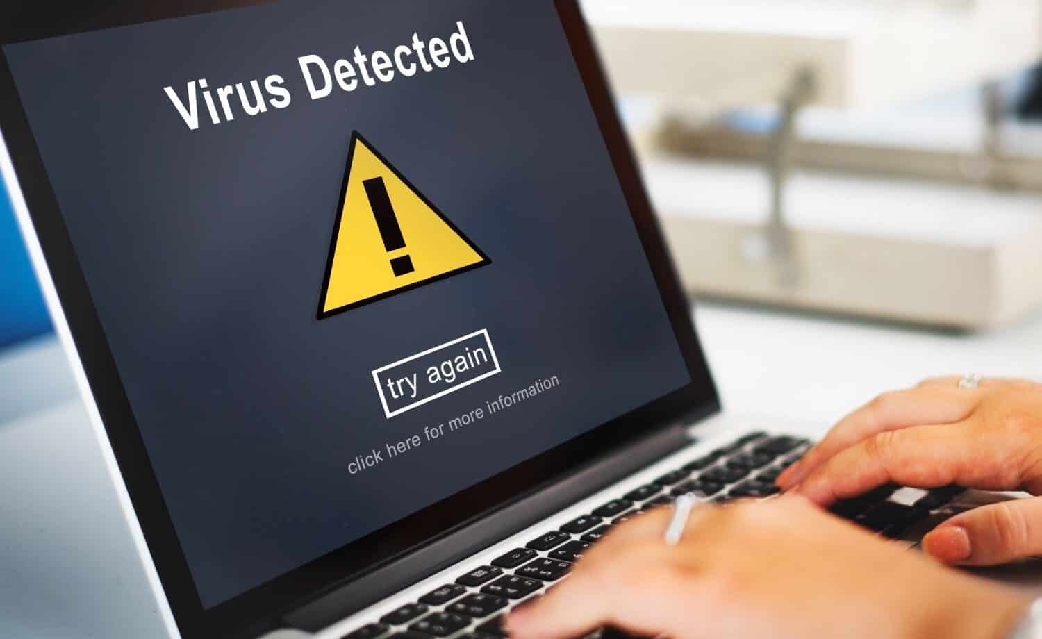 laptop screen with "virus detected" alert.