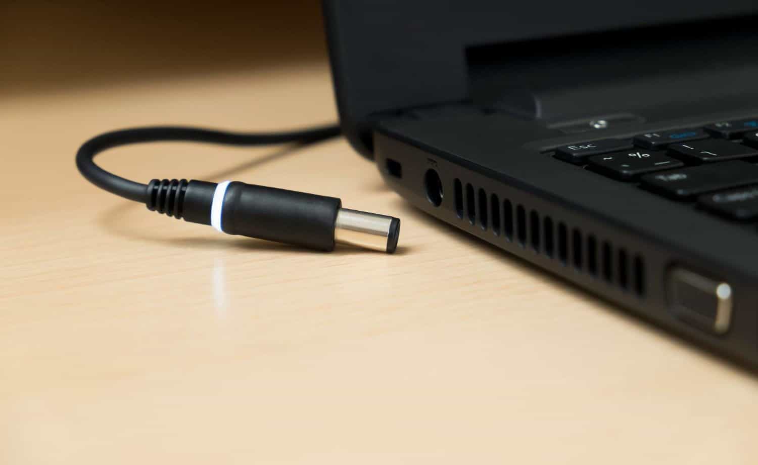 side view of laptop with a charger beside it