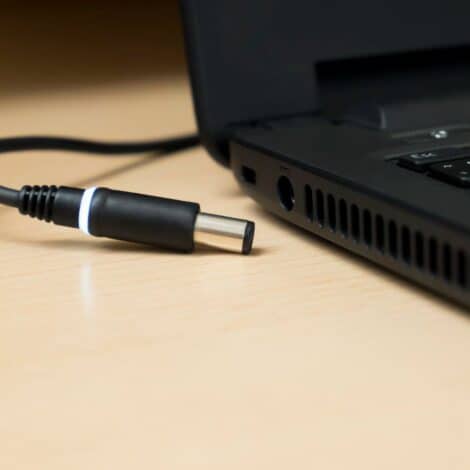 side view of laptop with a charger beside it