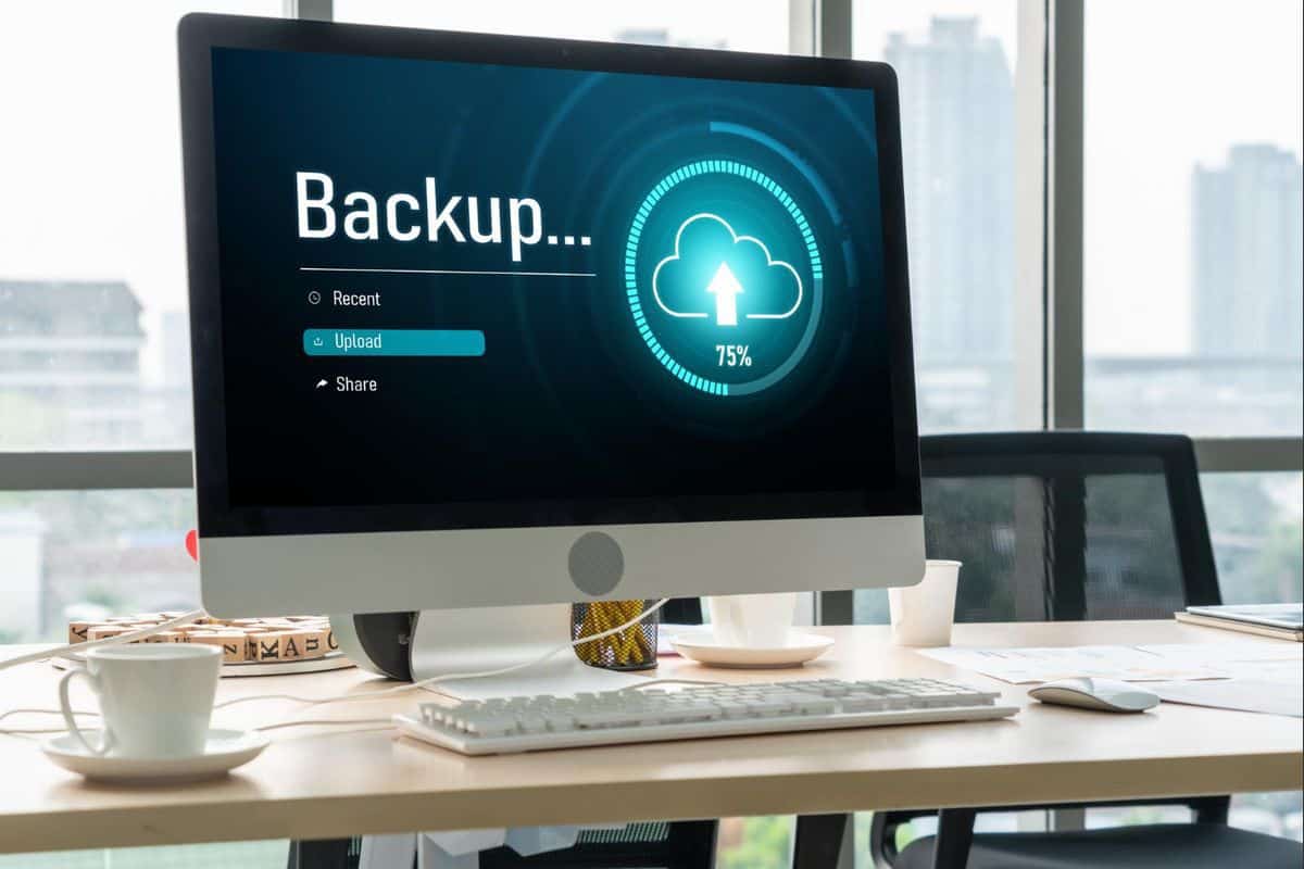 Desktop computer with a data backup progress bar showing 75%, representing Geeks On Command's data backup services to safeguard files.