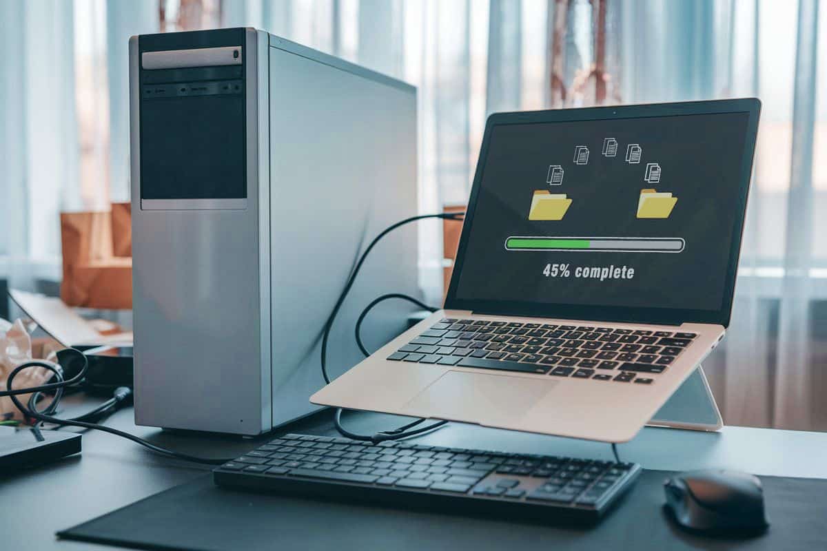 Desktop and laptop connected during data transfer, representing new PC setup services by Geeks On Command.