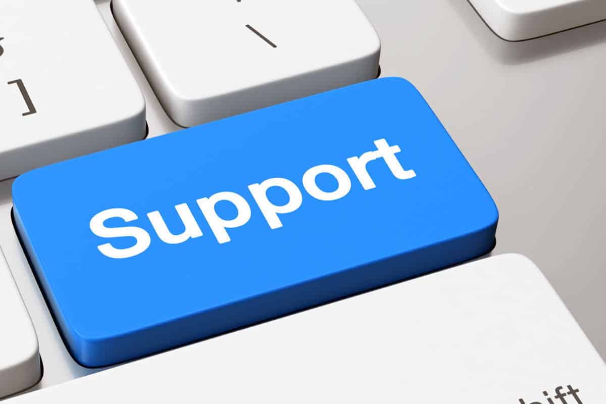 Close-up of a blue support button on a computer keyboard, representing instant access to technical assistance services.